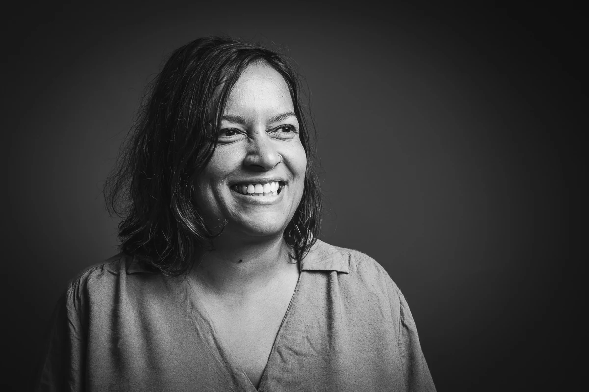 Lune Dargery, paysagiste, large sourire, regard tourné hors cadre, portrait noir et blanc horizontal en studio