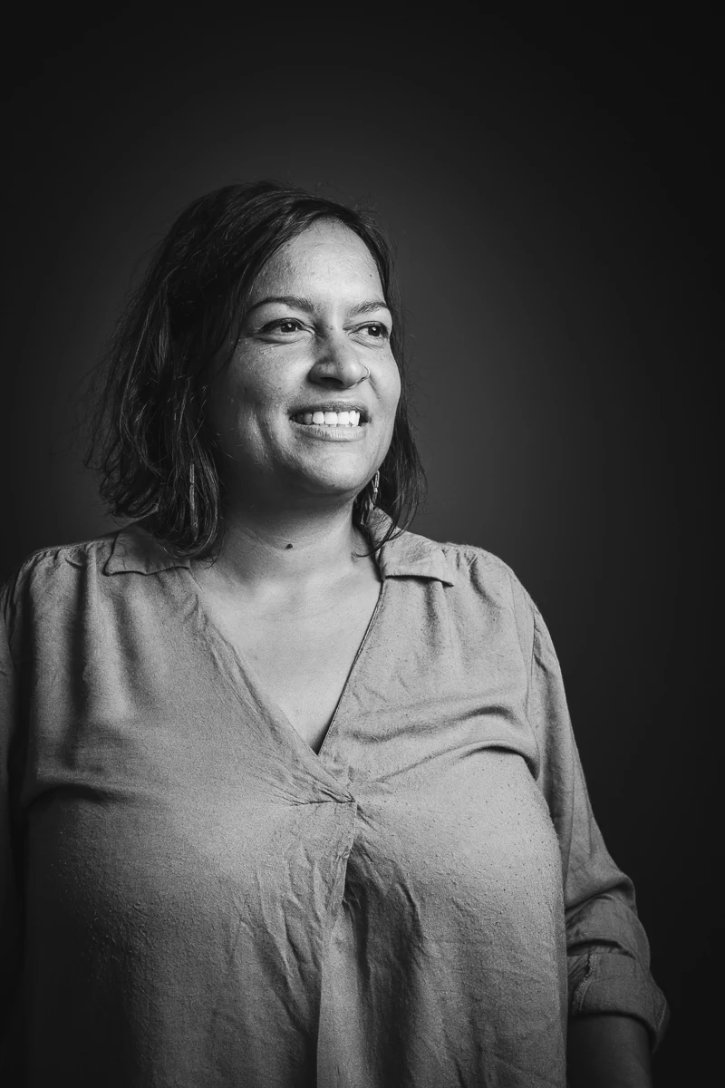 Lune Dargery, paysagiste, souriante, le regard tourné vers la lumière, portrait noir et blanc en studio