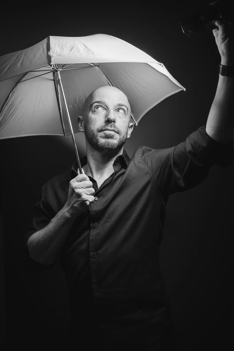 Thibault Maestracci, photographe portrait corporate, sous un parapluie de studio, le regard vers le haut